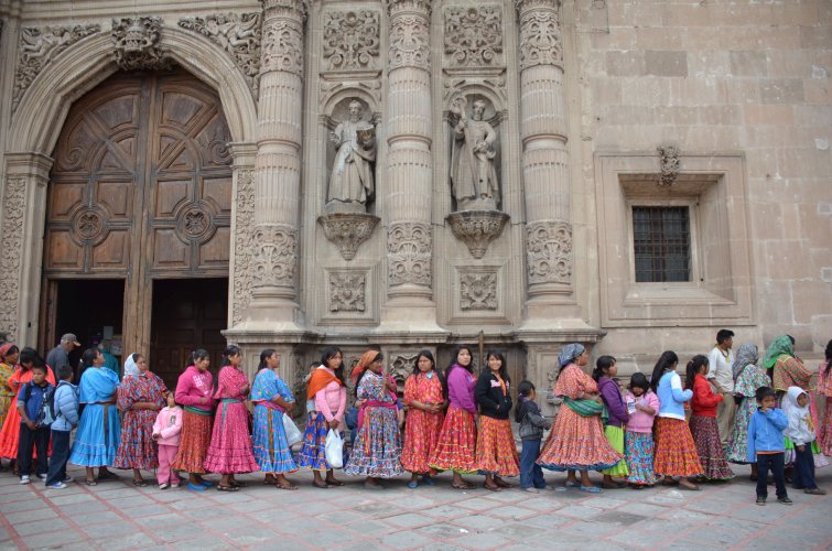 Foto de mujeres rarámuri haciendo fila en frente de la Catedral de Chihuahua